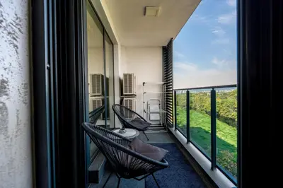a balcony with two chairs and a view of the ocean at Beni Deluxe in Plovdiv