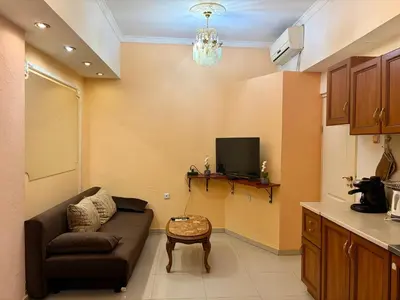 a living room with a couch and a tv at Prime Center - 1BDR Apt - Top Floor Next to the National Stadium & Sofia University in Sofia