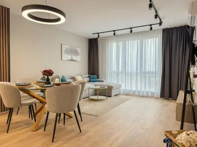 a living room with a table and a couch at 2BR Apartment in a Modern Complex with free Street Parking in Plovdiv