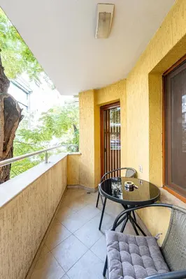 a balcony with a table and chairs and a window at Beni Deluxe 1 in Plovdiv