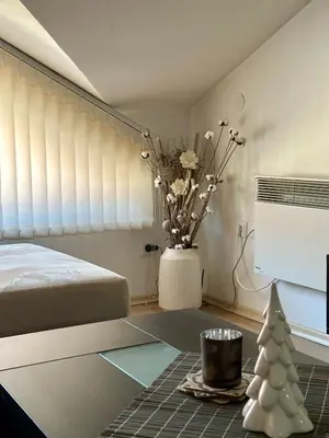 a bedroom with a bed and a vase with flowers at Alpine Apartment Home2Host in Bansko