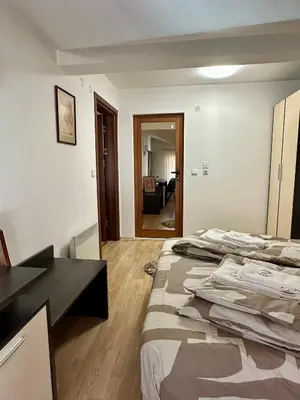 a hotel room with a bed and a desk in it at Alpine Apartment Home2Host in Bansko