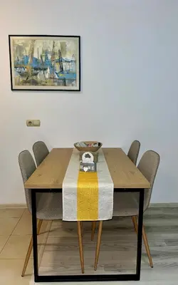 a dining room table with chairs and a painting on the wall at Cozy apartment Alba with two bedrooms! in Blagoevgrad