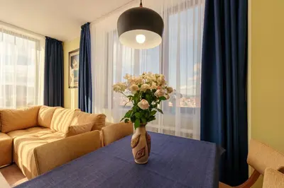 a vase of flowers on a table in a living room at Rila Sunshine Apartment in Samokov
