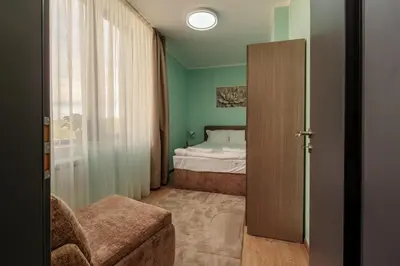 a bedroom with a bed and a door leading into a room at Rila Sunshine Apartment in Samokov
