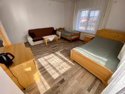 a small bedroom with a bed and a couch at Къща за гости 