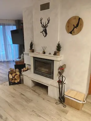 a living room with a fireplace and a clock on the wall at The Monastery 3 1B9-Mанастира 3 1Б9 in Pamporovo