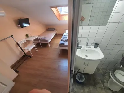 a bathroom with a sink and a bed in a room at Let's Go Party - Plovdiv Center in Plovdiv