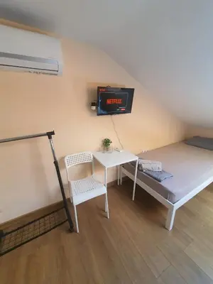a room with a bed and a table and a clock at Let's Go Party - Plovdiv Center in Plovdiv