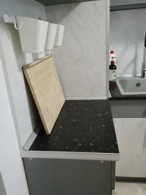 a kitchen counter with a wooden cutting board on it at Apartment With Free Parking - Center Plovdiv in Plovdiv