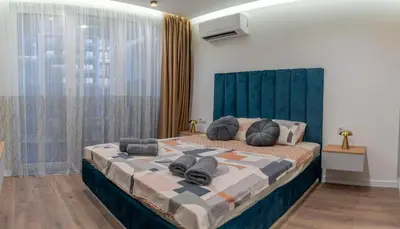 a bedroom with a large bed with a blue headboard at Luxury & Modern Apartment - Rowing Canal Plovdiv in Plovdiv
