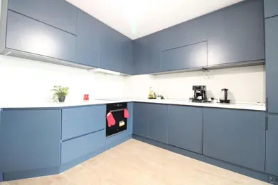 a kitchen with blue cabinets and white counter tops at Modern 1BR Apartment Plovdiv City Center Parking in Plovdiv