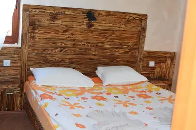 a bed with a wooden headboard and two pillows at Villa Pamporovo in Pamporovo