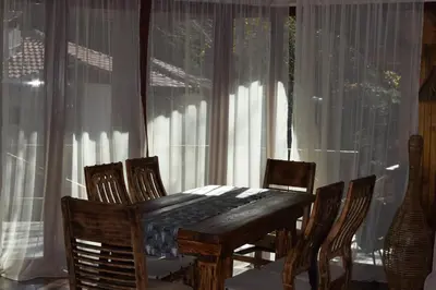 a wooden table and chairs in front of a window at Villa Pamporovo in Pamporovo