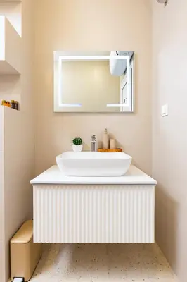 a bathroom with a white sink and a mirror at Royal Garden apartment with Private Parking in Plovdiv
