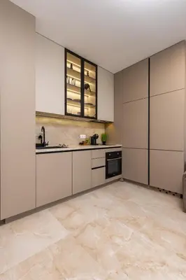 a kitchen with white cabinets and a tile floor at Royal Garden apartment with Private Parking in Plovdiv