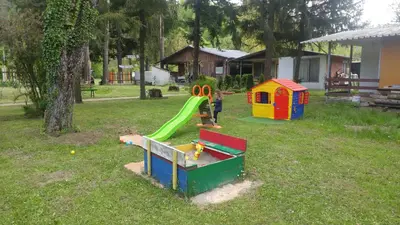 a child playing on a playground in a yard at Guest House Rainbow in Cherni Osŭm