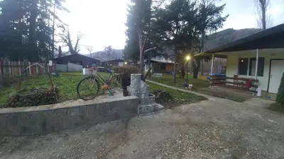 a bike parked on a stone wall next to a house at Guest House Rainbow in Cherni Osŭm