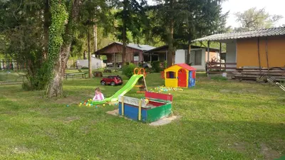 a child playing on a playground in a yard at Guest House Rainbow in Cherni Osŭm