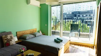 a bedroom with a bed and a couch and a large window at The BlackPeak View Apartment in Sofia