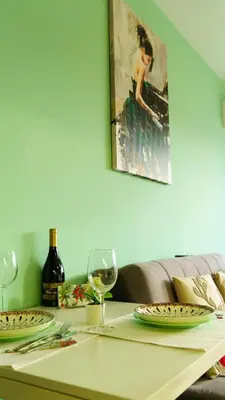 a table with plates and wine glasses on it at The BlackPeak View Apartment in Sofia