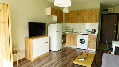 a kitchen with a white refrigerator and a table at The BlackPeak View Apartment in Sofia