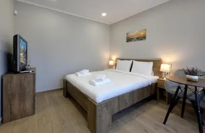 a bedroom with a bed and a tv and a desk at Portata in Plovdiv