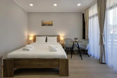 a bedroom with a large white bed and a table at Portata in Plovdiv