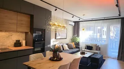 a kitchen and living room with a couch and a table at LUXURY Designer Apt I Meters to Gondola Lift I Sleeps 6 I Pool & Parking I in Bansko