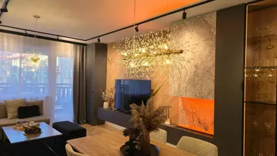 a living room with a tv and a table at LUXURY Designer Apt I Meters to Gondola Lift I Sleeps 6 I Pool & Parking I in Bansko
