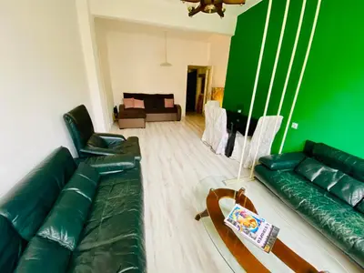 a living room with a couch and a green wall at Happy Appointment in Sofia