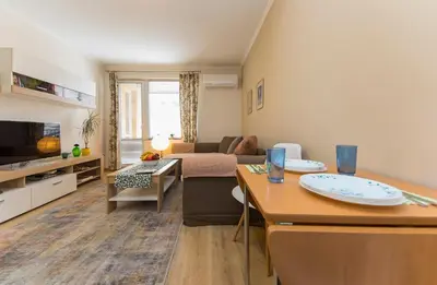 a living room with a couch and a table in a room at Lovely Central 1 Bedroom Condo in Sofia in Sofia