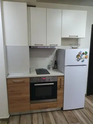a kitchen with white cabinets and a stove and a refrigerator at Sofia escape in Sofia