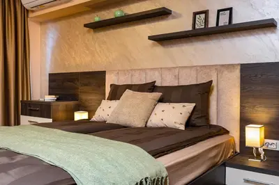 a bedroom with a large bed with a wooden headboard at Warm and Spacious 1BR Apt - Brownie in Plovdiv