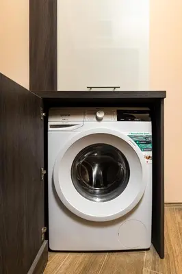 a washing machine in a cabinet in a room at Warm and Spacious 1BR Apt - Brownie in Plovdiv