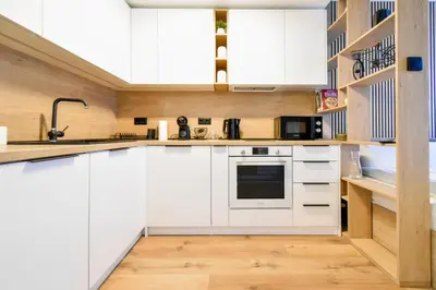a kitchen with white cabinets and a sink at Little Sugar Home in Sofia