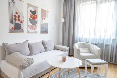 a living room with a white couch and a chair and a table at Old Town Bijou in Sofia