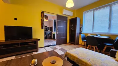 a living room with a television and a dining room at Cozy spot at the heart of Sofia in Sofia