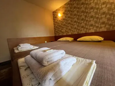 a room with two beds with towels on them at Къща за гости Орешака in Oreshak