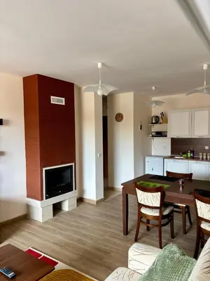 a living room with a table and a kitchen at Snow Apartment Bansko Home2Host in Bansko