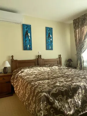 a bedroom with a bed and two pictures on the wall at Kandahar Apartment - top location in Bansko