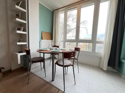 a dining room with a table and chairs and a window at Bogota Central Apt w Office Space and Wifi near Metro in Sofia