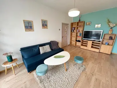 a living room with a blue couch and a table at Bogota Central Apt w Office Space and Wifi near Metro in Sofia