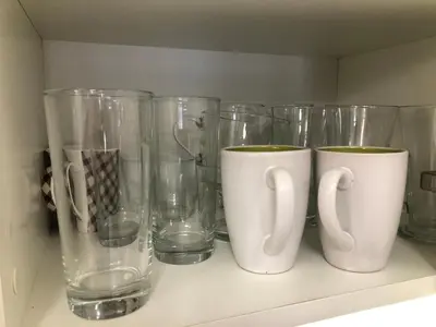 a row of glass vases and cups on a shelf at Artistic Neon Apartment in Bansko