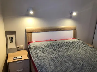 a bedroom with a bed with two lights above it at Artistic Neon Apartment in Bansko
