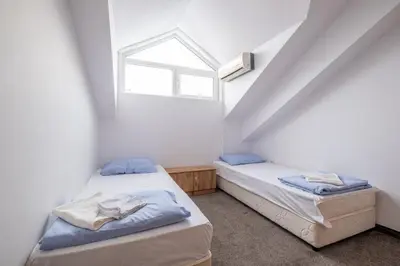 two twin beds in a room with a window at Julia rooms in Sofia