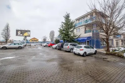 a parking lot with cars parked in front of a building at Julia rooms in Sofia