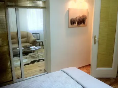 a bedroom with a bed and a living room with a couch at Gogol 2BR Apartment in Sofia