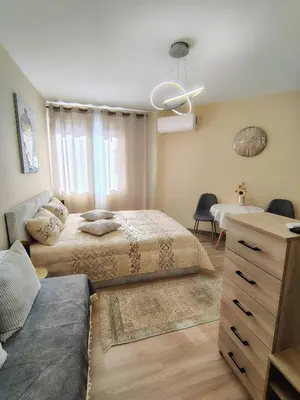 a bedroom with two beds and a couch and a table at Charming Studio 88 in Bansko