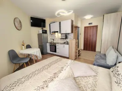 a bedroom with a large bed and a kitchen at Charming Studio 88 in Bansko
